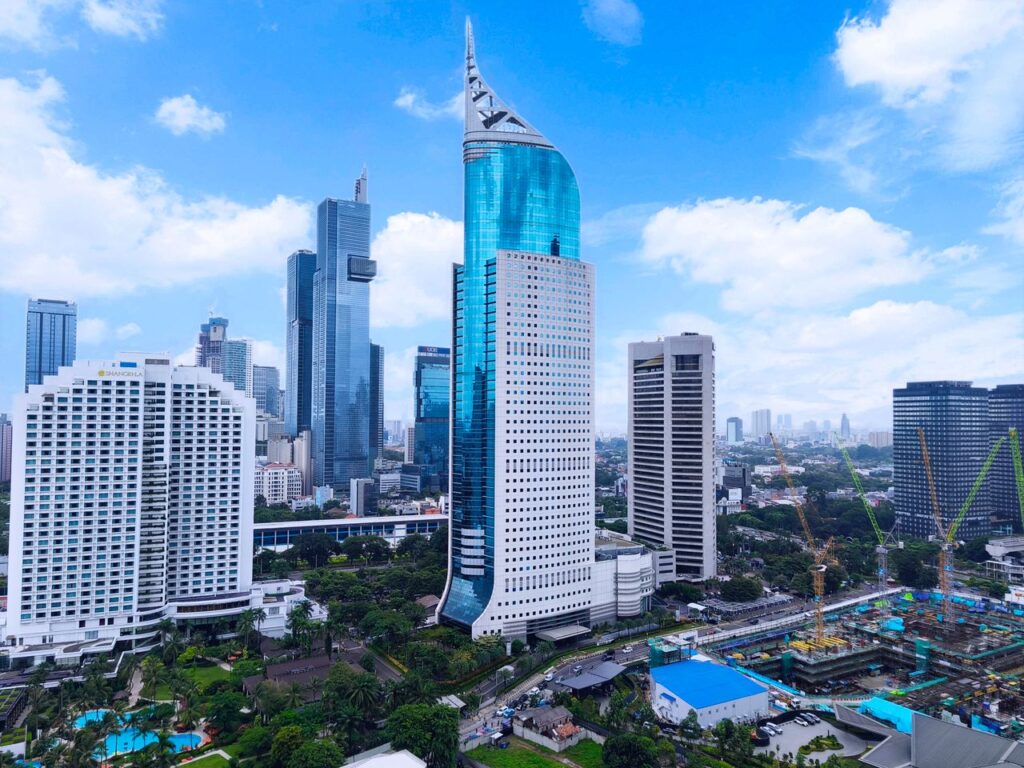 Aerial view of Jakarta featuring the iconic Wisma 46 and nearby skyscrapers.
