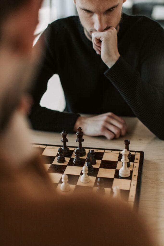 A man engaged in a strategic chess game indoors, highlighting focus and thought.